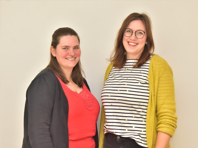 Das Bild zeigt einen Schreibtisch mit orangener Oberfläche, die Tastatur eines Laptops, einen Taschenrechner sowie einen Block mit Bleistift