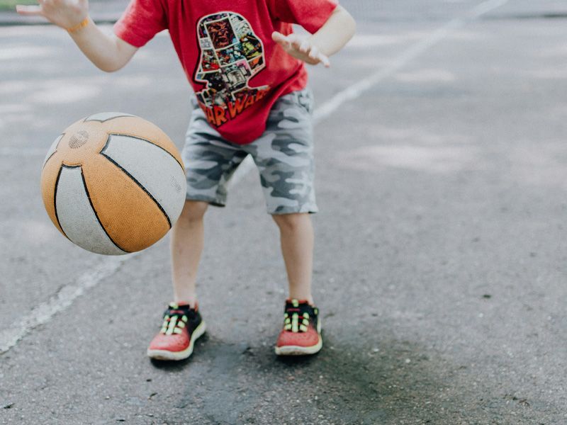 Ein kleiner Junge hat Spaß beim Basketballspielen und zeigt seine Begeisterung für den Sport.