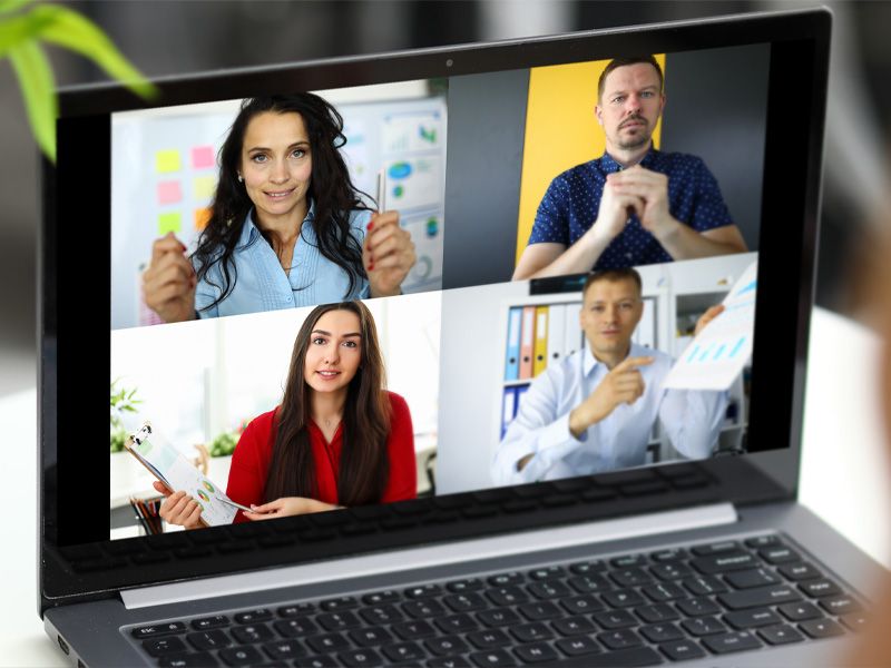 Das Bild zeight einen Laptop, auf dem gerade ein Online-Meeting mit 4 Personen abgehalten wird.